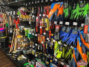 Bruce's Pet and Farm Supply wall display featuring a variety of gardening and farming tools, including shovels, rakes, hoses, pruners, and work gloves in multiple sizes and colors. The section is stocked with high-quality hand tools and accessories, ideal for gardeners, farmers, and hobbyists looking for reliable equipment.