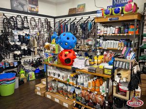 Bruce's Pet and Farm Supply interior showcasing a variety of horse care products, tack, and accessories, including bridles, halters, feed supplements, grooming sprays, and colorful treat dispensers. Store shelves are fully stocked with equine essentials from top brands, ideal for horse owners seeking quality farm and pet supplies in Maple Ridge.